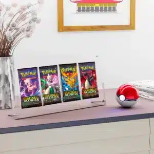 Protection acrylique 4 boosters UV Résistant (99,9%) est un coffret transparent de protection pour paquets de cartes Pokémon. On y voit 4 boosters de cartes Pokémon de face avec des personnages comme illustration. Les illustrations sont roses, violettes, bleues, jaunes et rouges. Le support repose sur deux petites barres rondes en métal, sur une planche avec une pokéball rouge et blanche sur la droite, devant une pile de 3 livres. Sur la gauche il y a un vase avec une plante et derrière sur le mur, un cadre marron avec un dessin de maison est accroché.