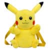 Sac à Dos Peluche Pokémon Pikachu. On voit un sac à dos en forme de peluche à l'effigie de Pikachu. Il est représenté de face, jaune, rouge aux joues et noir aux yeux et à la pointe des oreilles. Il a les bras levés vers le ciel.