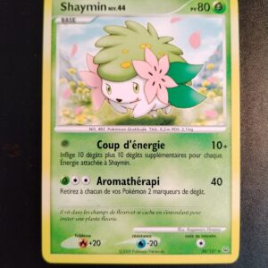 Shaymin 38/127. Carte du JCC Pokémon issue de la série Platine du bloc Platine, parue le 18/08/2009. Carte Pokémon de Base de type Plante, Rare. Illustrateur: Kagemaru Himeno. L'illustration représente un petit quadrupède blanc avec une crinière verte décorées de 2 grosses fleurs roses de part et d'autre de sa tête. La créature est représentée en train de courir dans une prairie fleurie bordée de montagnes.