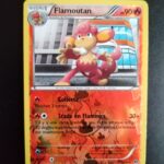 Flamoutan (reverse) 16/99. Carte du TCG Pokémon issue de la série Destinées Futures bloc Noir et Blanc (NB04), parue le 24/03/2012. Carte Pokémon Niveau 1 de type Feu, évolution de Flamajou, Rare. Illustrateur: Kouki Saito. L'illustration représente une sorte de petit singe rouge dans un paysage urbain, posant sur le bitume dos à de grands immeubles vitrés.