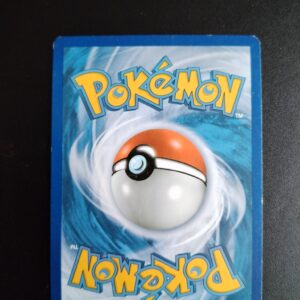 dos de la carte Groret (reverse) 50/146. Carte du TCG Pokémon issue de la série XY du bloc XY (XY01), parue le 22/02/2014. Carte Pokémon Niveau 1 de type Psy, évolution de Spoink, Rare. Illustrateur: sui. L'illustration du verso de cette carte représente une Pokéball en son centre. Il s'agit s'une sphère bicolore: rouge dans sa moitié supérieure et blanche pour la moitié inférieure. Le Logo Pokémon est répété au-dessus et en dessous de la Pokéball, en jaune. Le fond de la carte est de couleur bleue.