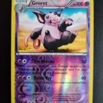 Groret (reverse) 50/146. Carte du TCG Pokémon issue de la série XY du bloc XY (XY01), parue le 22/02/2014. Carte Pokémon Niveau 1 de type Psy, évolution de Spoink, Rare. Illustrateur: sui. L'illustration représente un cochon rose et noir debout sur ses pattes arrières, il semble danser.
