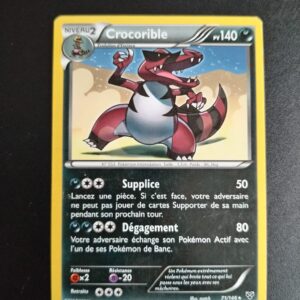 Crocorible 71/146. Carte du TCG Pokémon issue de la série XY du bloc XY (XY01), parue le 22/02/2014. Carte Pokémon Niveau 2 de type Ténèbres, évolution d'Escroco, Rare. Illustrateur: match. L'illustration représente un crocodile rouge rayé de noir avec des lunettes de soleil.