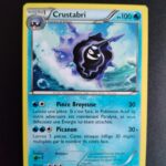 Crustabri 32/146. Carte du TCG Pokémon issue de la série XY du bloc XY (XY01), parue le 22/02/2014. Carte Pokémon Niveau 1 de type Eau, évolution de Kokiyas, Rare. Illustrateur: Masakazu Fukuda. L'illustration représente un crustacé de type escargot de mer noir, dans une grosse coquille violette qui surfe au-dessus de vagues.