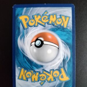 dos de la carte Brutalibré (holo) 63/111. Carte du TCG Pokémon issue de la série Poings Furieux du bloc XY (XY03, XY: Poins Furieux), parue le 23/08/2014. Carte Pokémon de Base de type Combat, Rare. Illustrateur: 5ban Graphics. L'illustration du verso de cette carte représente une Pokéball en son centre. Il s'agit d'une sphère bicolore: rouge dans sa moitié supérieure et blanche pour la moitié inférieure. Le Logo Pokémon est répété au-dessus et en dessous de la Pokéball, en jaune. Le fond de la carte est de couleur bleue.