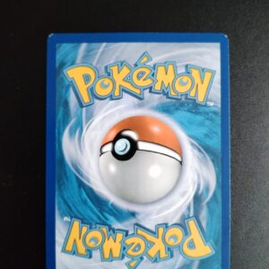 dos de la carte Golgopathe 49/106. Carte du TCG Pokémon issue de la série Etincelles du bloc XY (XY02, XY: Etincelles), parue le 27/05/2014. Carte Pokémon de Niveau 1 de type Combat, évolution d'Opermine. Rare. Illustrateur: 5ban Graphics. L'illustration du verso de cette carte représente une Pokéball en son centre. Il s'agit d'une sphère bicolore: rouge dans sa moitié supérieure et blanche pour la moitié inférieure. Le Logo Pokémon est répété au-dessus et en dessous de la Pokéball, en jaune. Le fond de la carte est de couleur bleue.