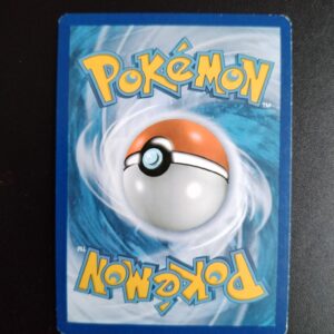 dos de la carte Noctunoir (holo) 40/106. Carte du TCG Pokémon issue de la série Etincelles du bloc XY (XY02, XY: Etincelles), parue le 27/05/2014. Carte Pokémon de Niveau 2 de type Psy évolution de Téraclope. Rare. Illustrateur: Suwama Chiaki. L'illustration du verso de cette carte représente une Pokéball en son centre. Il s'agit d'une sphère bicolore: rouge dans sa moitié supérieure et blanche pour la moitié inférieure. Le Logo Pokémon est répété au-dessus et en dessous de la Pokéball, en jaune. Le fond de la carte est de couleur bleue.