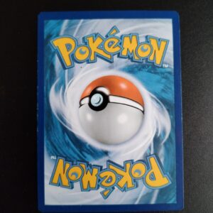 dos de la carte Démétéros 58/111. Carte du TCG Pokémon issue de la série Poings Furieux du bloc XY (XY03, XY: Poings Furieux), parue le 23/08/2014. Carte Pokémon de Base de type Combat, Rare. Illustrateur: PLANETA. L'illustration du verso de cette carte représente une Pokéball en son centre. Il s'agit d'une sphère bicolore: rouge dans sa moitié supérieure et blanche pour la moitié inférieure. Le Logo Pokémon est répété au-dessus et en dessous de la Pokéball, en jaune. Le fond de la carte est de couleur bleue.