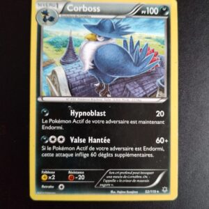 Corboss 52/119. Carte du TCG Pokémon issue de la série Vigueur Spectrale du bloc XY (XY04, XY: Vigueur Spectrale), parue le 08/11/2014. Carte Pokémon Niveau 1 de type Ténèbres, évolution de Cornèbre, Rare. Hajime Kusajima. L'illustration représente un volatile casqué perché sur le pignon d'un bâtiment ancien.