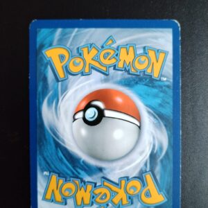 dos de la carte Kaorine 33/98. Carte du TCG Pokémon issue de la série Origines Antiques du bloc XY (XY07, XY: Origines Antiques), parue le 22/08/2015. Carte Pokémon de Niveau 1 de type Psy, évolution de Balbuto. Rare. Illustrateur: Satoshi Shirai. L'illustration du verso de cette carte représente une Pokéball en son centre. Il s'agit d'une sphère bicolore: rouge dans sa moitié supérieure et blanche pour la moitié inférieure. Le Logo Pokémon est répété au-dessus et en dessous de la Pokéball, en jaune. Le fond de la carte est de couleur bleue.