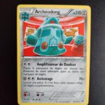Archéodong 96/162. Carte du TCG Pokémon issue de la série Impulsion Turbo du bloc XY (XY08, XY: Impulsion Turbo), parue le 07/11/2015. Carte Pokémon de Niveau 1 de type Métal, évolution de d'Archéomire. Rare. Illustrateur: Tomokazu Komiya. L'illustration représente un gros robot vert exposé comme une pièce de musée.