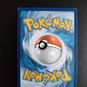 dos de la carte Hypnomade 51/122. Carte du TCG Pokémon issue de la série Rupture Turbo du bloc XY (XY09, XY: Rupture Turbo), parue le 06/02/2016. Carte Pokémon Niveau 1 de type Psy, évolution de Soporifik, Rare. Illustrateur: Tomokazu Komiya. L'illustration du verso de cette carte représente une Pokéball en son centre. Il s'agit s'une sphère bicolore: rouge dans sa moitié supérieure et blanche pour la moitié inférieure. Le Logo Pokémon est répété au-dessus et en dessous de la Pokéball, en jaune. Le fond de la carte est de couleur bleue.