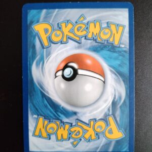 dos de la carte Tarinorme 55/114. Carte du TCG Pokémon issue de la série Offensive Vapeur du bloc XY (XY11, XY: Offensive Vapeur), parue le 16/08/2016. Carte Pokémon de Niveau 1 de type Combat, évolution de Tarinor. Rare. Illustrateur: MAHOU. L'illustration du verso de cette carte représente une Pokéball en son centre. Il s'agit d'une sphère bicolore: rouge dans sa moitié supérieure et blanche pour la moitié inférieure. Le Logo Pokémon est répété au-dessus et en dessous de la Pokéball, en jaune. Le fond de la carte est de couleur bleue.