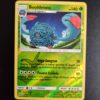 Bouldeneu (reverse) 8/147. Carte du TCG Pokémon issue de la série Ombres Ardentes du bloc Soleil et Lune (SL03, SL: Ombres Ardentes), parue le 19/08/2017. Carte Pokémon de Niveau 1 de type Plante, évolution de Saquedeneu. Rare. Illustrateur: tetsuya Koizumi. L'illustration représente une créature à la peau violette couverte de long cheveux gris-bleus. Elle évolue sur une plaine dans la nuit.