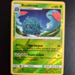 Bouldeneu (reverse) 8/147. Carte du TCG Pokémon issue de la série Ombres Ardentes du bloc Soleil et Lune (SL03, SL: Ombres Ardentes), parue le 19/08/2017. Carte Pokémon de Niveau 1 de type Plante, évolution de Saquedeneu. Rare. Illustrateur: tetsuya Koizumi. L'illustration représente une créature à la peau violette couverte de long cheveux gris-bleus. Elle évolue sur une plaine dans la nuit.