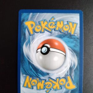 dos de la carte Camérupt (reverse) 14/111. Carte du TCG Pokémon issue de la série Invasion Carmin du bloc Soleil et Lune (SL04, SL: Invasion Carmin), parue le 04/11/2017. Carte Pokémon de Niveau 1 de typeFeu, évolution de Chamallot. Rare. Illustrateur: Anesaki Dynamic. L'illustration du verso de cette carte représente une Pokéball en son centre. Il s'agit d'une sphère bicolore: rouge dans sa moitié supérieure et blanche pour la moitié inférieure. Le Logo Pokémon est répété au-dessus et en dessous de la Pokéball, en jaune. Le fond de la carte est de couleur bleue.