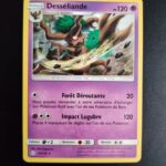 Desséliande 94/236. Carte du TCG Pokémon issue de la série Eclipse Cosmique du bloc Soleil et Lune (SL12, SL: Eclipse Cosmique), parue le 01/11/2019. Carte Pokémon de Niveau 1 de type Psy, évolution de Brocélôme. Rare. Illustrateur: Shin Nagasawa. L'illustration représente un arbre cyclopéen à l'oeil rouge en train de donner un coup de branche.