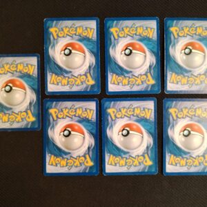 dos des cartes du lot de 7 cartes en états variables/mauvais état. Cartes du TCG Pokémon issue de la série Indomptable du bloc HeartGold SoulSilver (HS: Indomptable), parue le 06/11/2010. Entraînement de Sage 77/90 (illustrateur: Masakazu Fukuda), Malosse 53/90 (illustrateur: Kawayoo), Baudrive 46/90 (illustrateur: Kagemaru Himeno), Tadmorv 50/90 (illustrateur: Midori Harada), Limagma 67/90 -illustrateur: Yuka Morii), Scorplane 49/90 (illustrateur: Naoki Saito), Rattatac reverse 34/90 (illustrateur: Sachiko Adachi).L'illustration du verso de ces cartes représente une Pokéball en son centre. Il s'agit s'une sphère bicolore: rouge dans sa moitié supérieure et blanche pour la moitié inférieure. Le Logo Pokémon est répété au-dessus et en dessous de la Pokéball, en jaune. Le fond de la carte est de couleur bleue.