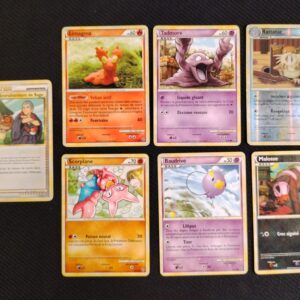 lot de 7 cartes en états variables/mauvais état. Cartes du TCG Pokémon issue de la série Indomptable du bloc HeartGold SoulSilver (HS: Indomptable), parue le 06/11/2010. Entraînement de Sage 77/90 (illustrateur: Masakazu Fukuda), Malosse 53/90 (illustrateur: Kawayoo), Baudrive 46/90 (illustrateur: Kagemaru Himeno), Tadmorv 50/90 (illustrateur: Midori Harada), Limagma 67/90 -illustrateur: Yuka Morii), Scorplane 49/90 (illustrateur: Naoki Saito), Rattatac reverse 34/90 (illustrateur: Sachiko Adachi). Les cartes sont présentées du côté recto, alignées sur 2 rangées.