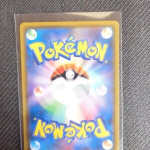 Dos Carte Pokémon Evoli Munch Promo Evoli 287/SM-P. Carte du TCG Pokémon promo issue du bloc Soleil et Lune parue du 27 Octobre 2018 au 20 Janvier 2019. Carte Pokémon de type Neutre. Promo. Illustrateur: Atsuko Nishida. L'illustration représente le Pokémon évoli qui a peur à la manière des tabeaux de l'artiste Edvard Munch, debout sur ses pattes arrières les mains à côté de sa bouche ouverte. La carte est rouge, vert et marron. On distingue le Pokémon Psykakwak derrière. Sur l'image du dos on voit Le logo Pokémon sur fond bleu, typique du dos des cartes japonaises.