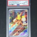 Detective Pikachu Returns Pre-order 098/sv-p PSA10 Carte Pokémon. Carte du TCG Pokémon promo issue du bloc Ecarlate et Violet parue en 2023. Carte Pokémon de type électrique. Promo. Illustrateur: Minaminami Take. L'illustration représente le Pokémon Pikachu avec une loupe assis sur caninos qui marche dans la rue. La carte est orange, jaune, grise et ocre. Elle reprend le célèbre jeu et film détective pikachu.