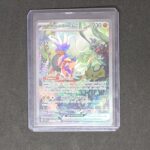 Koraidon ex 247 EV01 Pokémon Écarlate et Violet. Carte du TCG Pokémon issue du bloc Écarlate et Violet et du set écarlate et violet parue le 31 mars 2023. Carte Pokémon de type Combat. 247/198. Ryota Murayama. L'illustration représente le Pokémon Koraidon qui marche dansLa forêt.